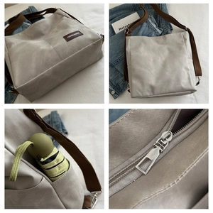 Detail view of grey canvas tote bag with side pocket holding a small folding umbrella