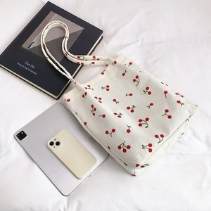 Dettaglio della borsa tote in velluto a coste bianco con stampe di ciliegie rosse