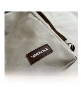 Detailed macro view of beige canvas fabric with leather fashion patch and metal buckle