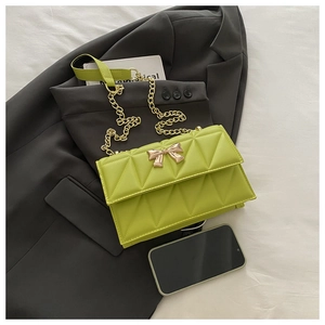 Detailed close-up of quilted pattern and gold bow-knot clasp on neon green crossbody bag