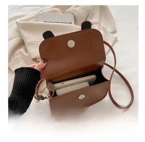 Detail showing internal capacity of the brown leather bag with phone and wallet