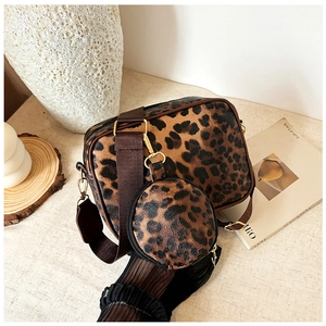 Detail view of the leopard print crossbody bag set with wide brown strap and gold hardware