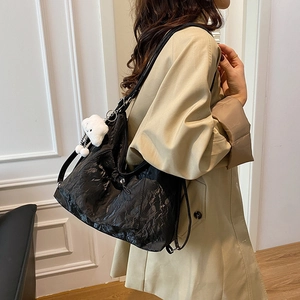 Minimalist black PU leather tote bag with glossy pleated texture and plush lamb pendant