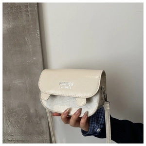Detail of cream PU crossbody bag with elegant marble pattern texture and fashion logo