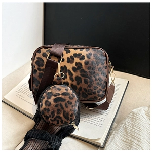 Detailed view of leopard print crossbody bag set on books with adjustable strap