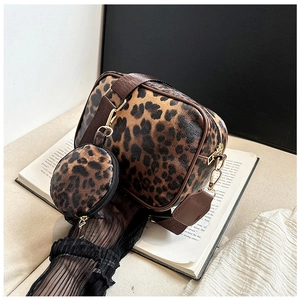 Detailed shot of leopard print crossbody bag with matching round coin purse on beige background
