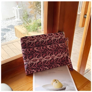 Detail of pink leopard print clutch bag with dual zippers and matching wrist strap