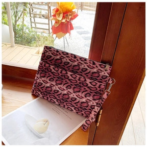 Detailed macro view of a pink leopard print canvas wristlet bag with a secure zipper strap