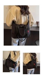 Detail view of the black nylon tote bag showing the adjustable strap and short handles
