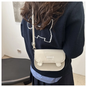 Side view of model wearing a creamy white minimalist crossbody square bag on shoulder