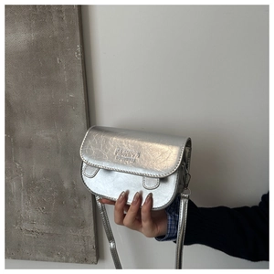 Detail view of silver textured leather mini square bag with embossed fashion lettering