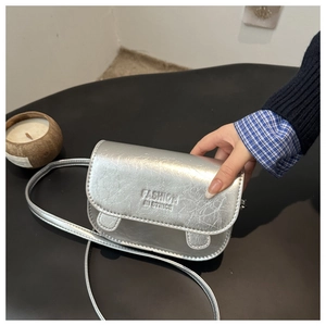 Detail of silver metallic crossbody bag featuring embossed fashion lettering and PU texture