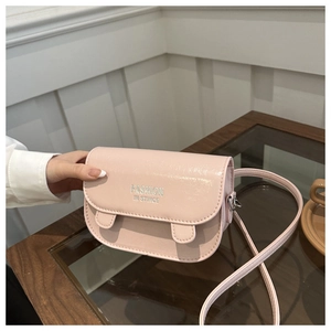 Close-up of the light pink glossy leather small square bag with silver fashion text detail