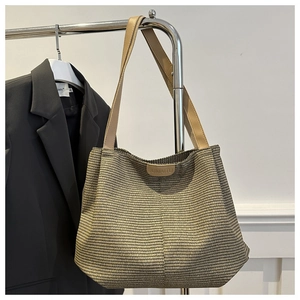 Dettaglio della grande borsa tote intrecciata con trama geometrica e tracolla in pelle