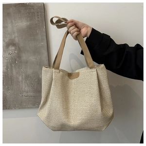 Dettaglio della trama in paglia e della toppa in pelle sulla borsa tote grande capiente