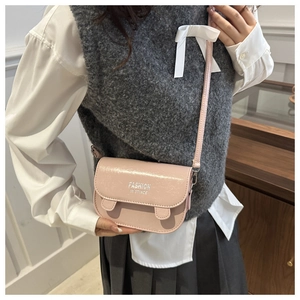 Pink patent leather mini crossbody bag with Fashion In Stince text detail worn by model