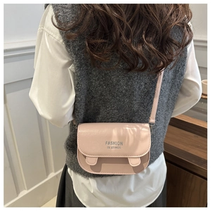 Detail of pink crossbody bag with adjustable strap and Fashion In Stince lettering