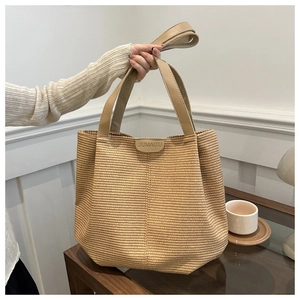 Vista dettagliata della borsa tote intrecciata con cinturini in pelle PU ed etichetta