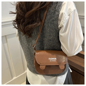 Brown faux leather crossbody bag with rounded U-shape and fashion lettering detail