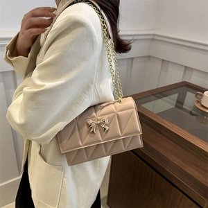 Quilted beige shoulder bag with golden bow clasp and chain strap for women