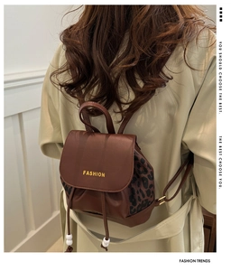 Detail eines braunen Lederrucksacks mit Leopardenmuster und Kordelzugverschluss