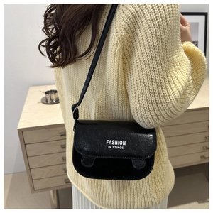 Detail of black matte leather square bag with fashion text print on adjustable shoulder strap