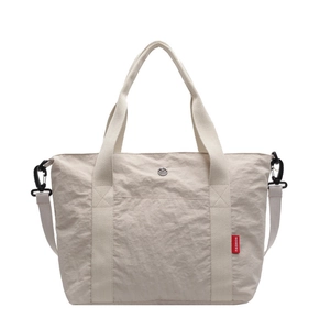 Minimalist beige nylon tote bag with reinforced handles and adjustable crossbody strap