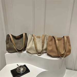 Tre borse tote in tessuto nei colori verde, bianco e marrone su display moderno