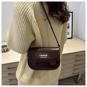 Close-up of retro brown messenger bag with vintage oil-wax leather texture and fashion text