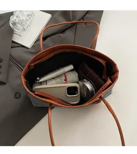 Top view of a large capacity grey tote bag filled with daily essentials and leather handles