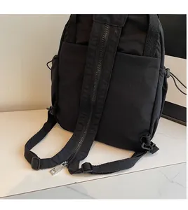 Détail du sac à dos multifonctionnel noir montrant la bandoulière zippée et les poches de côté