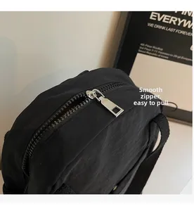 Vue détaillée de la fermeture éclair en métal argenté sur un sac à dos en nylon noir