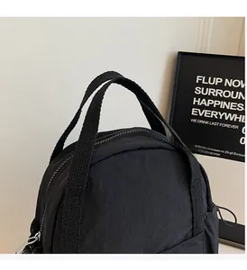 Détail de la poignée renforcée et de la fermeture éclair métallique sur sac à dos noir