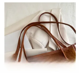 Detailed shot of the leather shoulder strap with a golden adjustable metal buckle