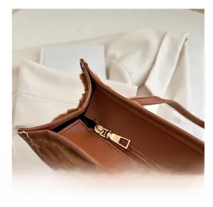 Close-up of golden metal zipper on brown plush and PU leather tote bag details