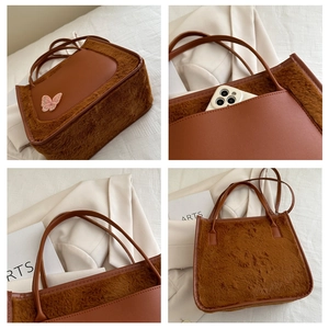 Detail view of brown faux fur tote bag with butterfly embroidery and spacious interior