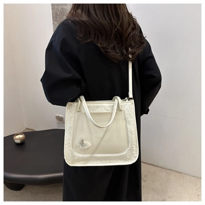 Detail of cream faux leather shoulder bag with plush fur trim and mesh butterfly applique