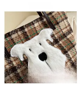 Close-up of retro plaid tweed tote bag with plush white dog patch and embroidery detail