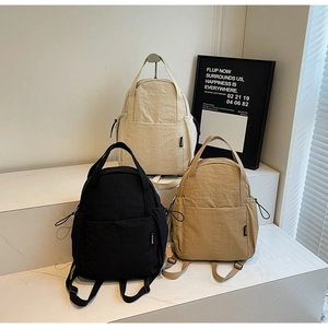 Trois sacs à dos en nylon minimalistes en noir, beige et kaki avec poches latérales