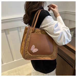 Detail of winter faux fur and PU leather tote bag with elegant butterfly embroidery