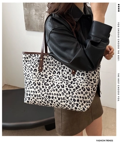 Fashionable leopard print tote bag with brown leather handles and gold rivet detail