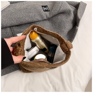 Détails de l'intérieur du sac seau en peluche marron montrant le fermoir magnétique