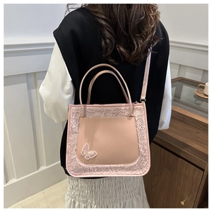 Pink plush faux leather tote bag with butterfly embroidery shown on a model