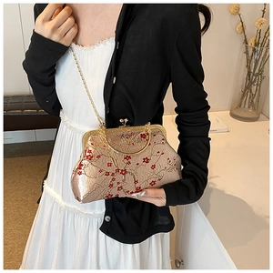 Detail of champagne satin evening bag with red floral embroidery and gold handle
