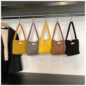 Détail de sacs fourre-tout en peluche de différentes couleurs avec étiquettes de mode