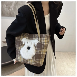 Detail of checkered tweed tote bag featuring a 3D plush schnauzer dog patch and leather strap