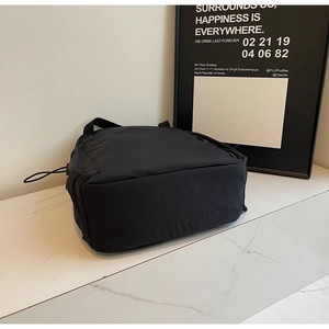 Détail du sac en nylon noir avec poignées renforcées et cordon de serrage réglable
