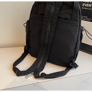 Détail de la sangle de sac à dos en nylon noir avec fermeture éclair et poche latérale