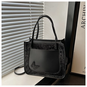 Detailed close-up of a black faux fur and leather tote bag featuring a 3D butterfly design