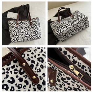 Detail of leopard print canvas tote featuring leather straps and golden rivet accents